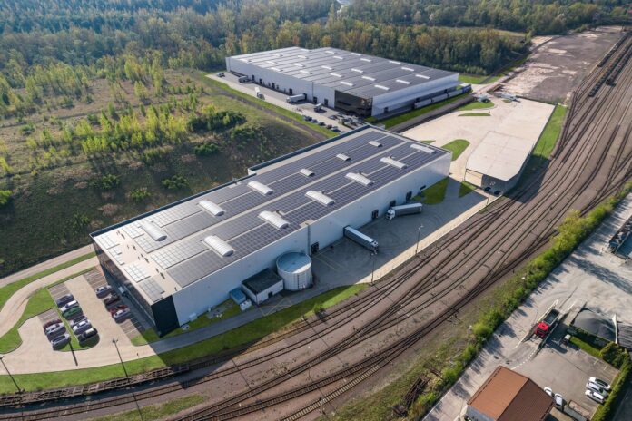 Vizualizace haly DMC2 v Paskově s napojením na železniční vlečku a solárními panely na střeše