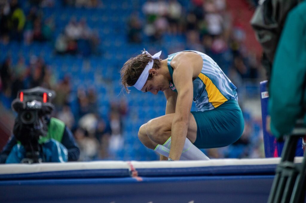 Armand Duplantis klečí po výkonu, hlavou dolů