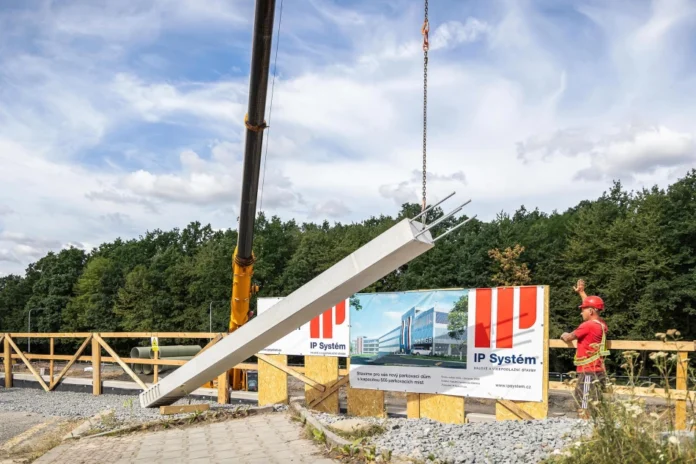 slavnostní poklepání na první sloup stavby, který poté stotunový autojeřáb vztyčil na své místo. Konec bloudění za parkováním FNO se blíží. Začátek stavby
