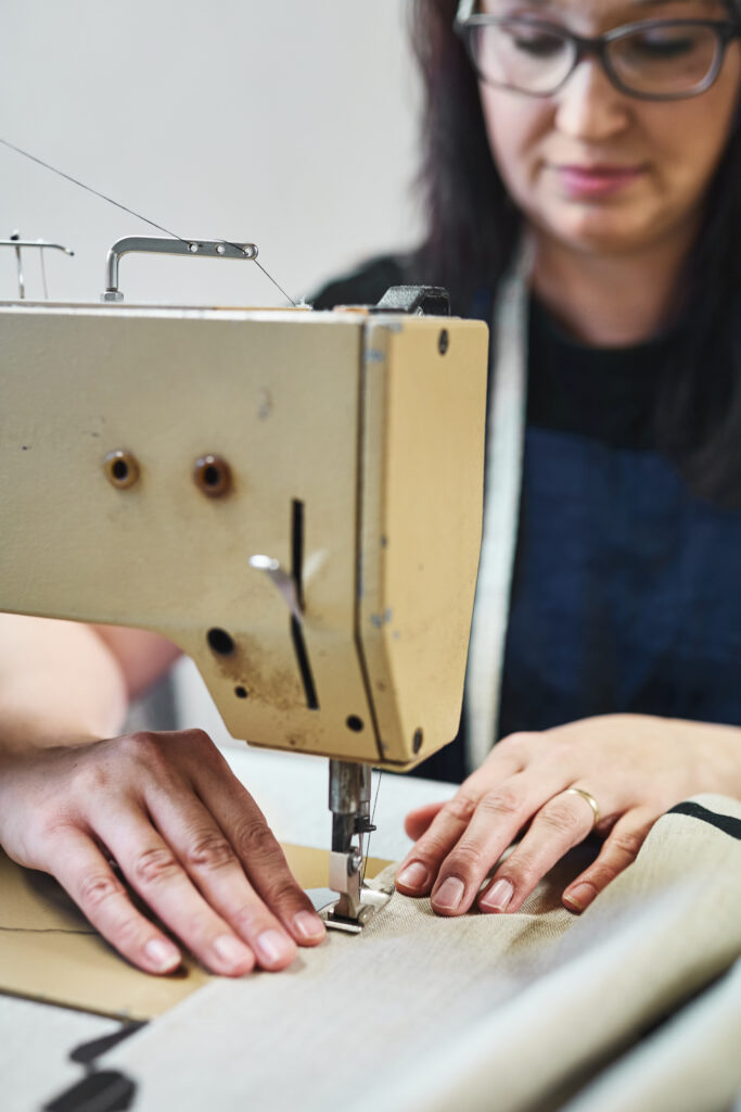 Švadlena šije lněný textil na stroji